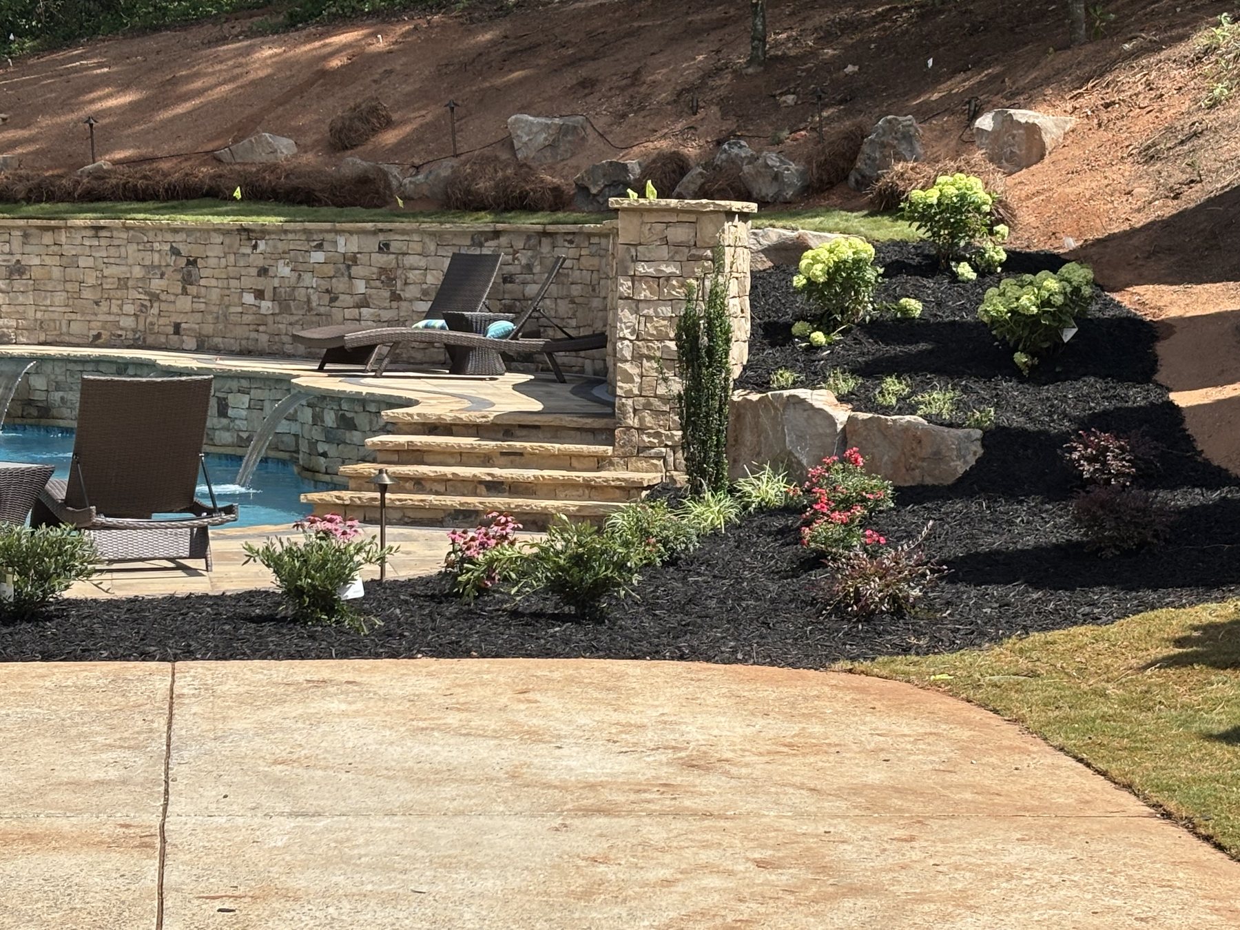 Poolside retaining wall, stone steps, planting beds, and finished hardscape detail